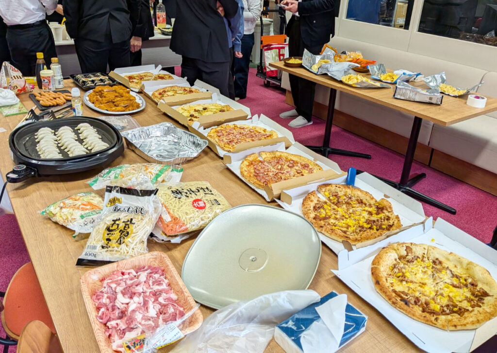 机に並べられたピザ7枚と焼いている餃子